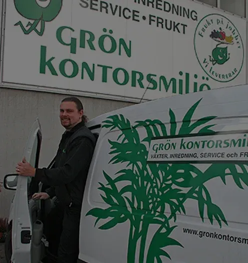 Medarbetare vid Grön Kontorsmiljös servicebil med handmålad logotyp